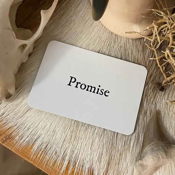 Card with 'Promise' text on a wooden surface with natural elements