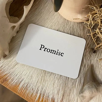 Card with 'Promise' text on a wooden surface with natural elements